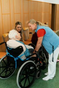 A private nurse assists an elderly client in a wheelchair.