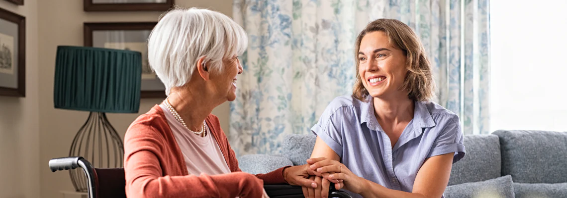 Caregiver holding the hand of her patient.